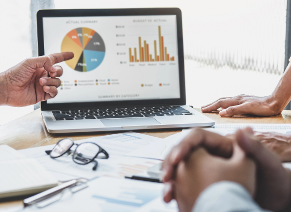 Header - SPE Evaluation Photo of a team huddles around a monitor showing charts